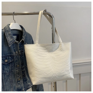 Detailed close-up of white PU tote bag featuring 3D bone embossed texture and large capacity