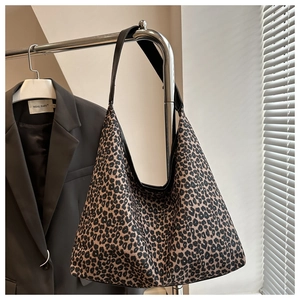 Detailed scene of a leopard print tote bag hanging on a rack with a brown suit blazer