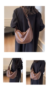 Detail of a large dark brown crescent tote with vintage oil wax leather texture