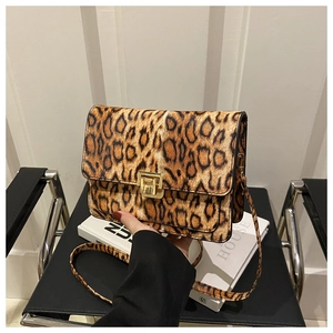 Close-up of leopard print crossbody bag with golden twist lock and faux fur texture