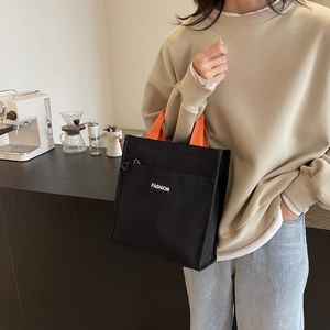 Sac fourre-tout en toile noire avec poignées oranges et poche frontale zippée pratique