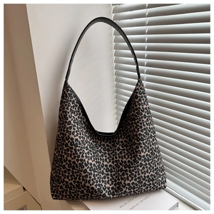 Detail of hobo shoulder bag featuring leopard print fabric and black leather strap