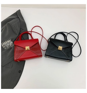 Detail of red and black crocodile embossed envelope bags with gold square studs