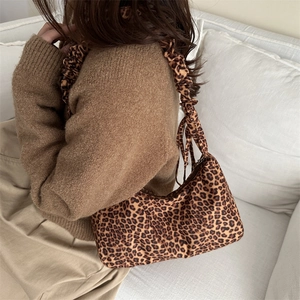 Leopard print canvas shoulder bag with pleated strap in a minimalist retro style
