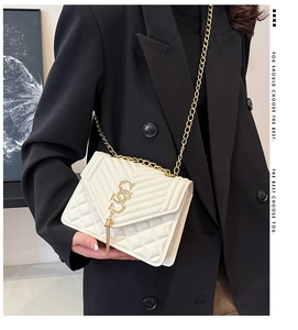 Détail du sac à bandoulière matelassé blanc avec chaîne dorée et glands élégants