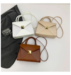 Detailed view of vintage crossbody bags with crocodile texture and gold pyramid studs
