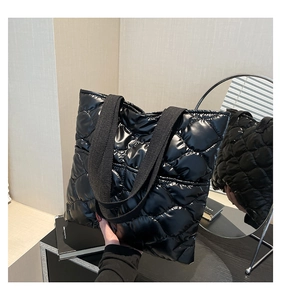 Macro shot of black quilted space cotton tote bag with shiny finish and wide webbed handles