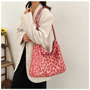 Detailed view of red leopard print canvas hobo bag with wide shoulder strap