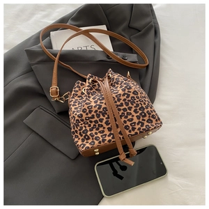 Detail of leopard print bucket bag with leather base and metal feet on a blazer