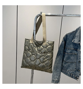 Detailed wave quilted texture on olive gold padded tote bag with beige fabric straps