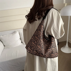 Leopard print canvas tote bag with black leather shoulder straps for daily commuting