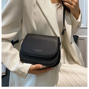 Detail der minimalistischen schwarzen Satteltasche mit FASHION TREND Schriftzug auf Leder