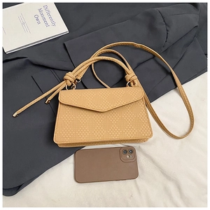 Détail de la texture tissée petit sac bandoulière carré avec poignée décorative à nœud