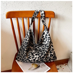 Detailed view of leopard print canvas tote bag hanging on a chair in a cozy setting