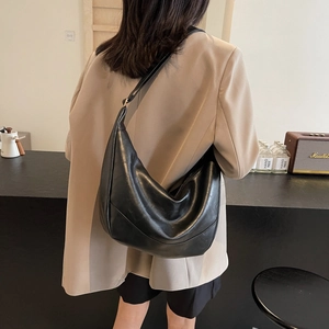 Minimalist black PU leather crescent tote bag with a spacious interior and soft texture