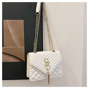 Détail du sac matelassé blanc avec logo SS doré et bandoulière en chaîne élégante
