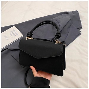 Detail of black crossbody bag featuring a knotted handle and elegant gold-tone metal buckles