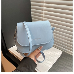Detailansicht der hellblauen Satteltasche mit Fashion-Trend-Prägung auf schlichtem Grund