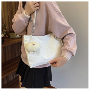 Detailed view of white tote bag with metal chain strap and cute cloud plush charm