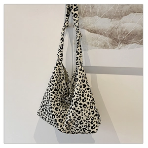 Detail einer Canvas-Tragetasche mit Leopardenmuster und geknotetem breitem Schultergurt