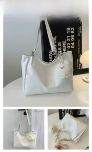 Détail du grand sac cabas en similicuir blanc avec chaînes et pendentif en peluche