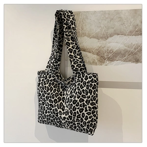 Leopard print canvas tote bag hanging on wall with abstract painting background