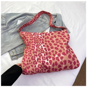 Close-up of pink and red leopard print canvas tote bag with wide shoulder strap details