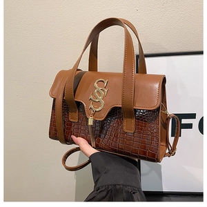 Detail of vintage brown leather handbag with gold SS buckle and tassel accent