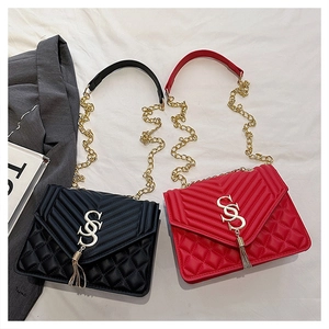 Détail de sacs bandoulière en cuir matelassé avec pompon en métal et logo