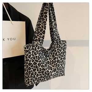 Close-up of leopard print tote bag with wide shoulder straps in a stylish urban setting