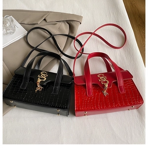 Close-up of crocodile pattern leather texture with gold SS logo and tassel detail