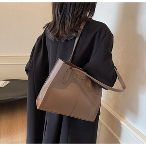 Detail view of khaki faux leather tote bag showing the debossed FASHION text and matte texture