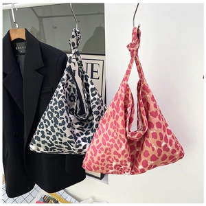 Detail of knotted shoulder straps on stylish leopard print canvas tote bags in two colors