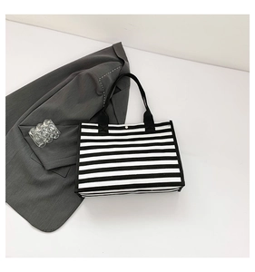 Detail shot of the black and white striped canvas tote bag with thick fabric handles