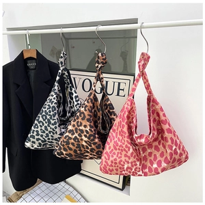 Three trendy leopard print canvas tote bags in brown, grey and pink displayed on a hanger