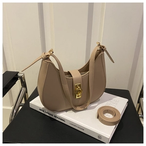 Détail du sac demi-lune beige montrant le fermoir doré et la texture du cuir PU de qualité