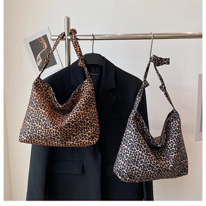 Detail of the leopard print tote bag featuring a decorative knot on the shoulder strap