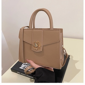 Detail of solid color PU leather handbag featuring a vintage gold flower clasp and handles