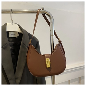 Gros plan sur le sac sous le bras en cuir marron vintage avec un fermoir doré