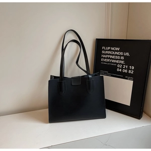 Detail shot of black tote bag on marble surface with minimalist interior decor