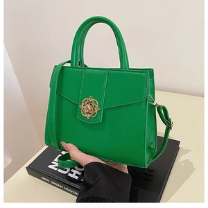Detailed shot of the green faux leather handbag with a vintage gold floral metal clasp