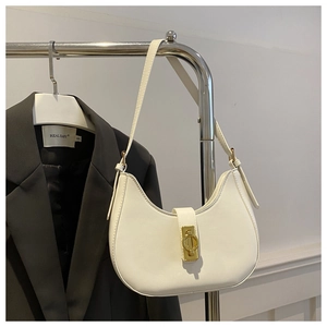 Détail du sac hobo blanc crème avec fermoir rotatif doré et texture en cuir mat