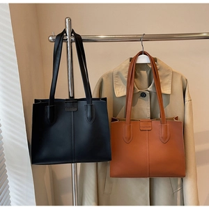 Close-up of minimalist matte PU leather tote bags in black and caramel brown colors