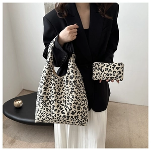 Gros plan du sac cabas en velours côtelé léopard et sa pochette sur un mannequin