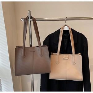 Detailed close-up of coffee and beige tote bags with vertical stitching and magnetic buckle