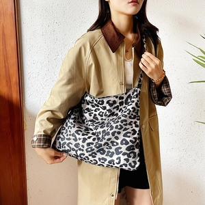 Chic black and white leopard print canvas tote bag shown on model with shoulder strap