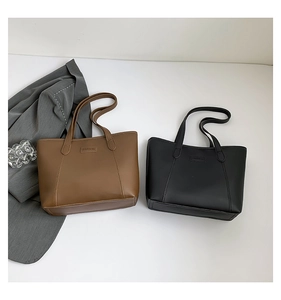 Close-up of FASHION embossed logo on premium leather tote bags in brown and black