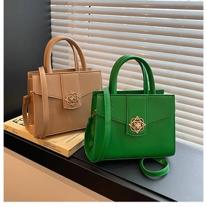 Detail of elegant handbags with gold flower hardware and adjustable shoulder straps