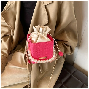 Dettaglio borsa a scatola rosa con manico di perle e fodera in raso con coulisse