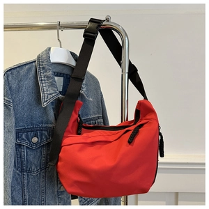 Detail of red nylon crescent crossbody bag with adjustable wide strap and sturdy plastic buckle